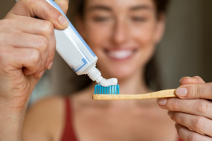 Woman applying toothpaste to her toothbrush